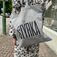 Tygkasse ljusgrå med svart text Styrka 